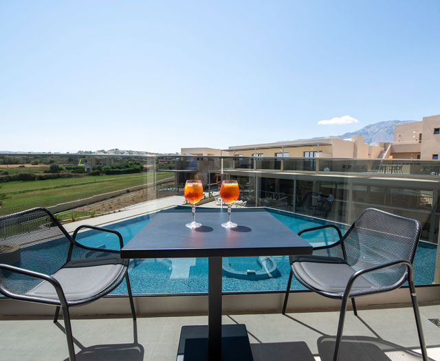 Ventale Island Breeze Resort Horizon Maisonette Pool View balcony with table, chairs, two cocktails and pool view